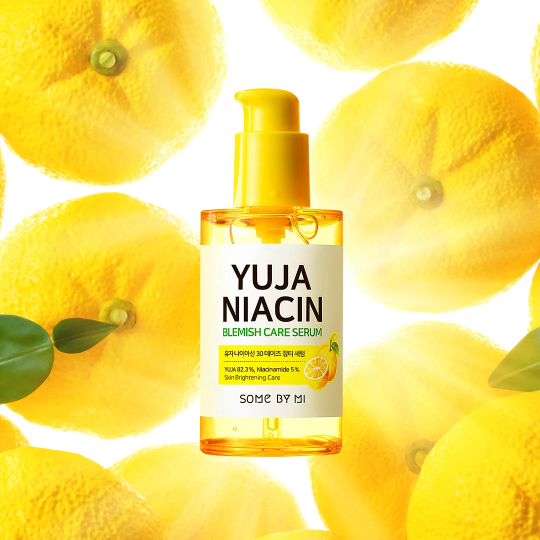 Chai serum Some By Mi Yuja Niacin Blemish Care Serum màu vàng với nắp bơm, đặt giữa nền hình các quả yuzu tươi sáng.