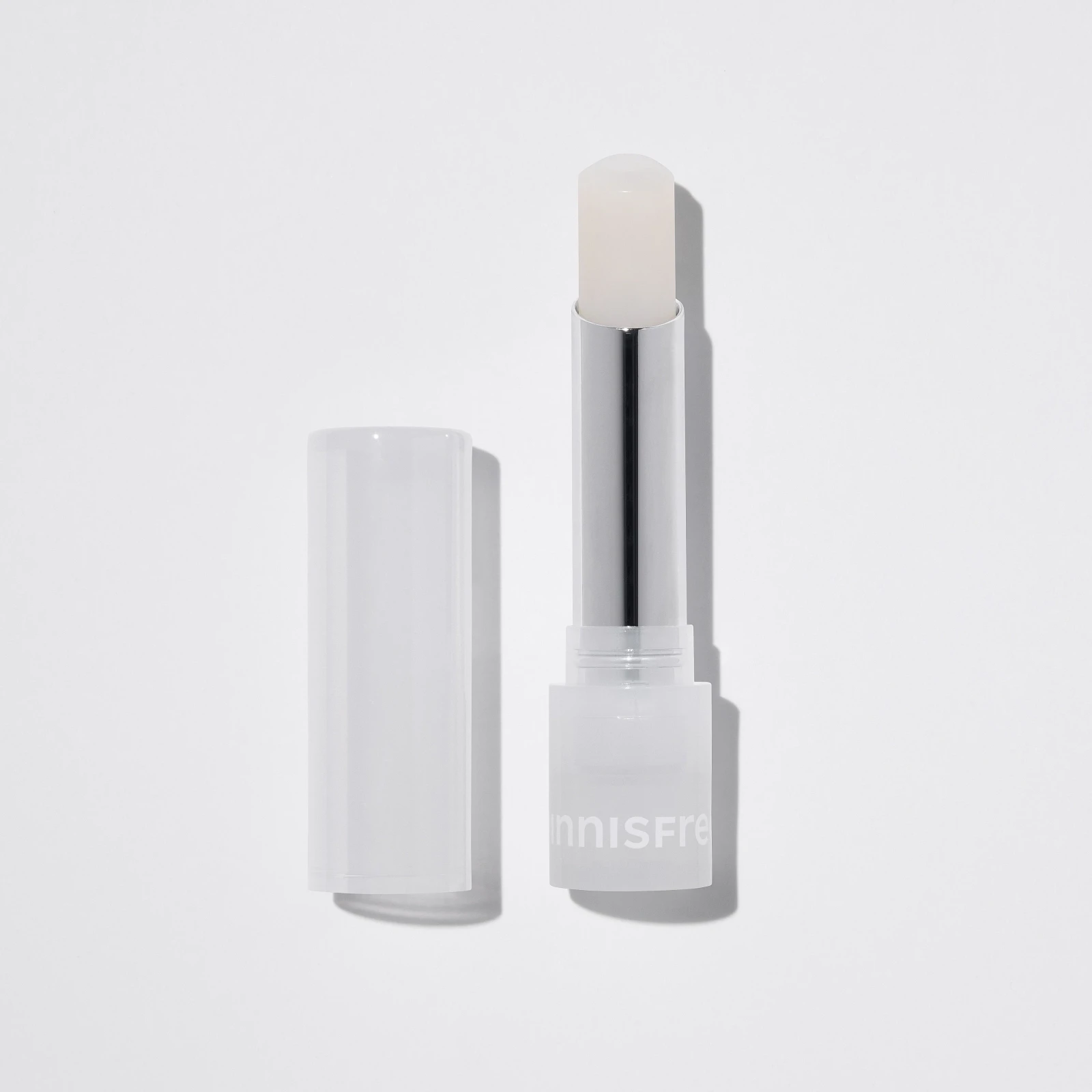 Son dưỡng có màu Innisfree Eco Science Tint Balm, mở nắp, hiển thị thân son trong suốt và đầu son màu trắng ngà trên nền trắng